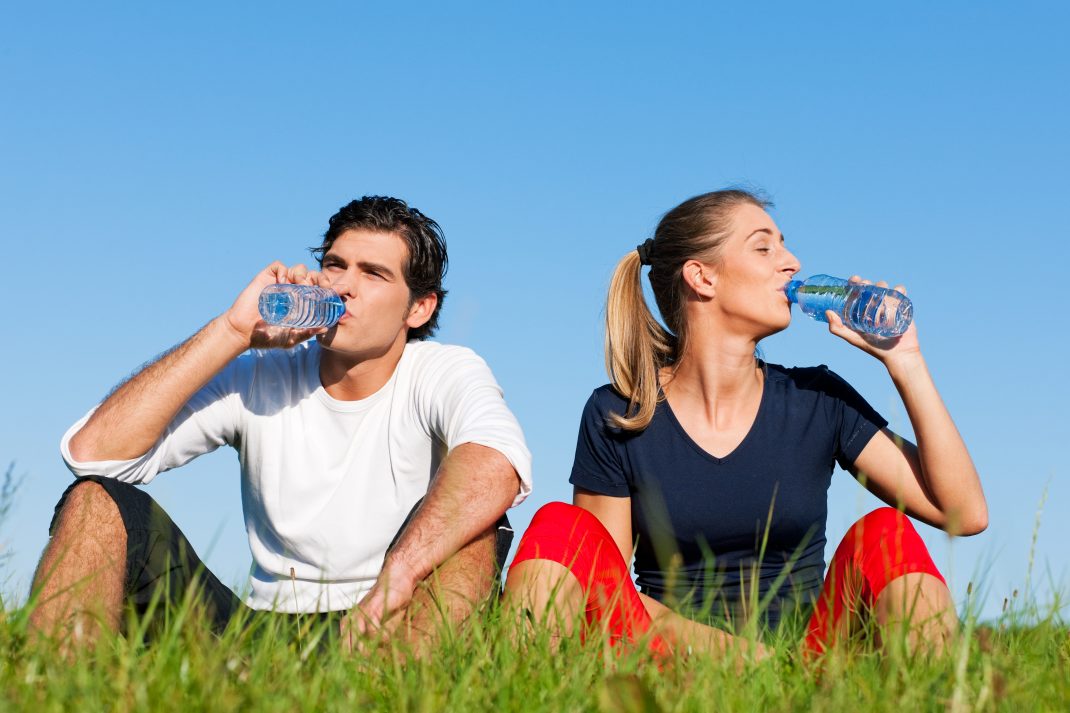 A couple drinking bottled water, emphasizing the risks of plastic bottles and the promotion of healthier alternatives.