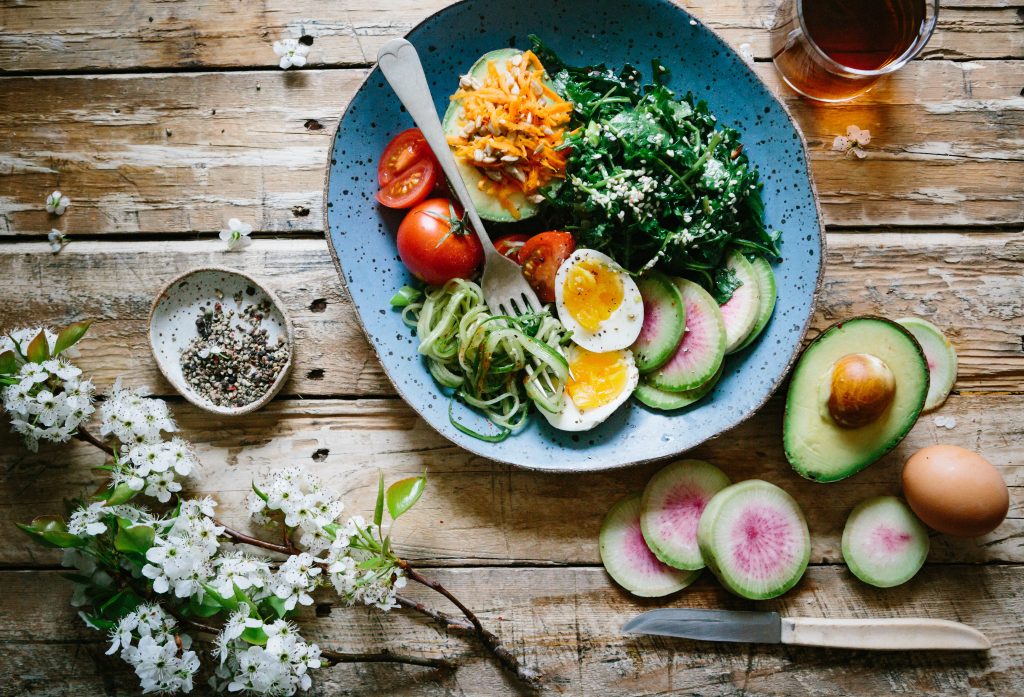 A colorful mix of avocado, eggs, tomatoes, and greens in a salad, emphasizing foods that help build a resilient immune system.