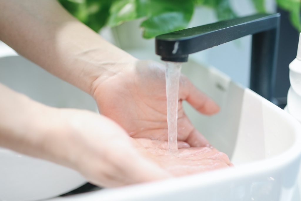 A picture showing hands being washed in a wash basin, signifying the importance of handwashing in preventing liver diseases like Hepatitis.