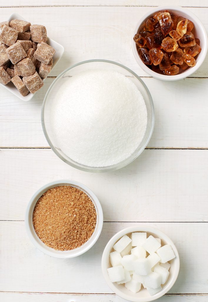 Assorted bowls of different types of sugar on display, showcasing various sugar options.