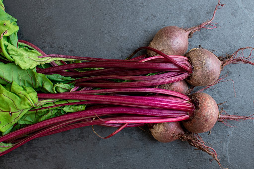 Freshly picked beetroot and leaves on the ground, showcasing their natural ability to help lower blood pressure.