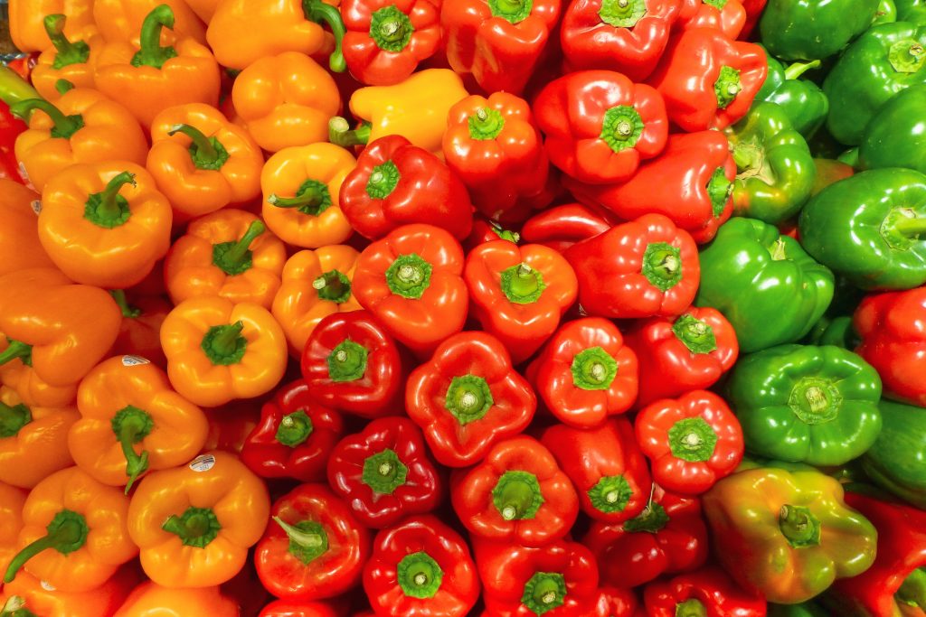 Bell peppers, an anti-inflammatory superfood, in red, yellow, and green colors, neatly displayed.