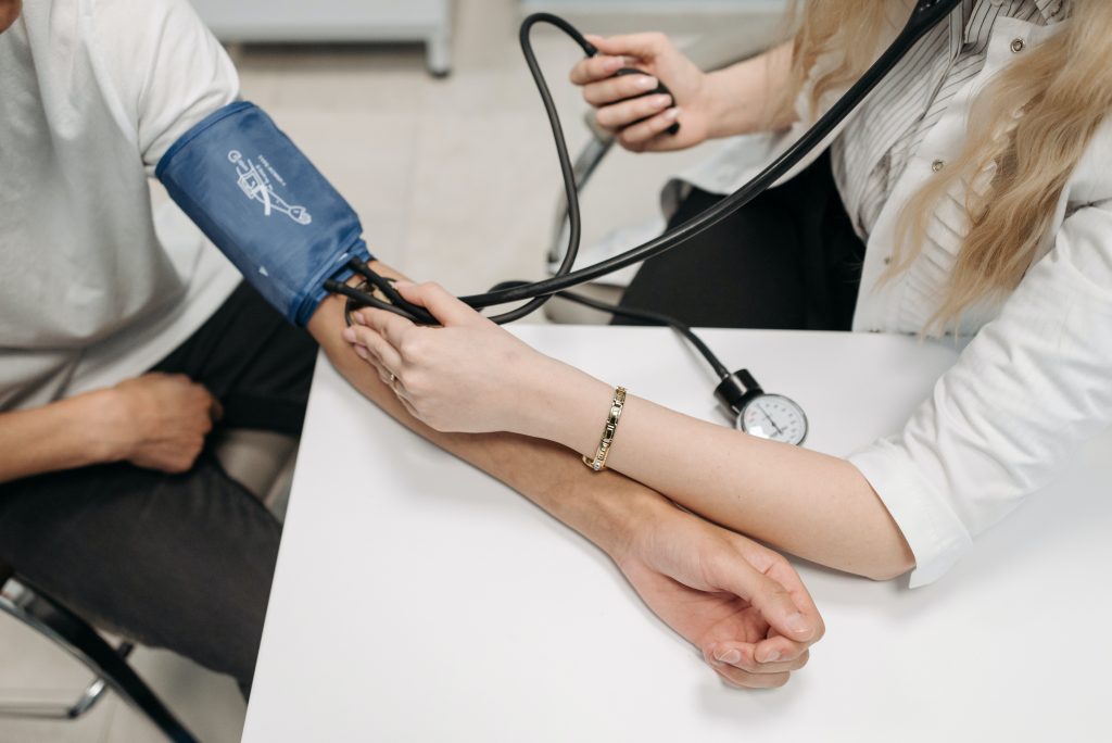 A doctor checking the blood pressure of a patient.