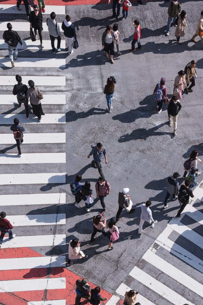 A top view of a busy pedestrian crossing, with people walking in different directions.