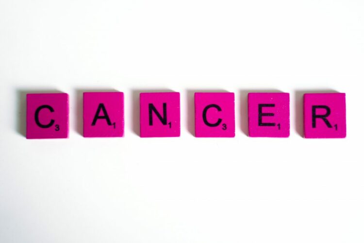 The word 'CANCER' spelled out using Scrabble tiles.