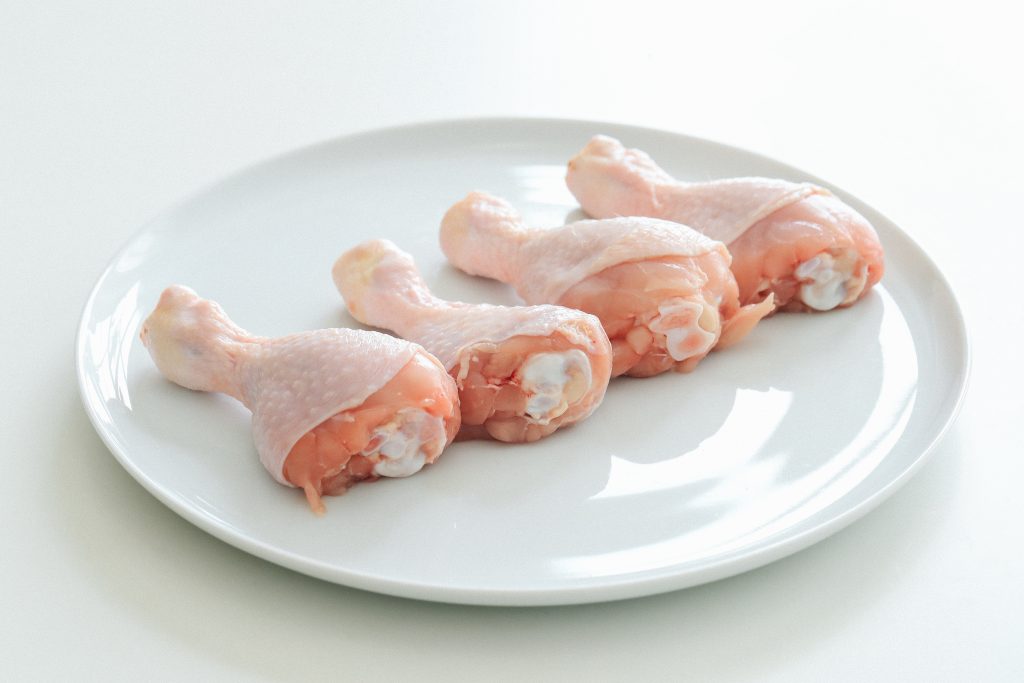 Chicken pieces with skin, rich in vitamins A and B, neatly arranged on a plate.