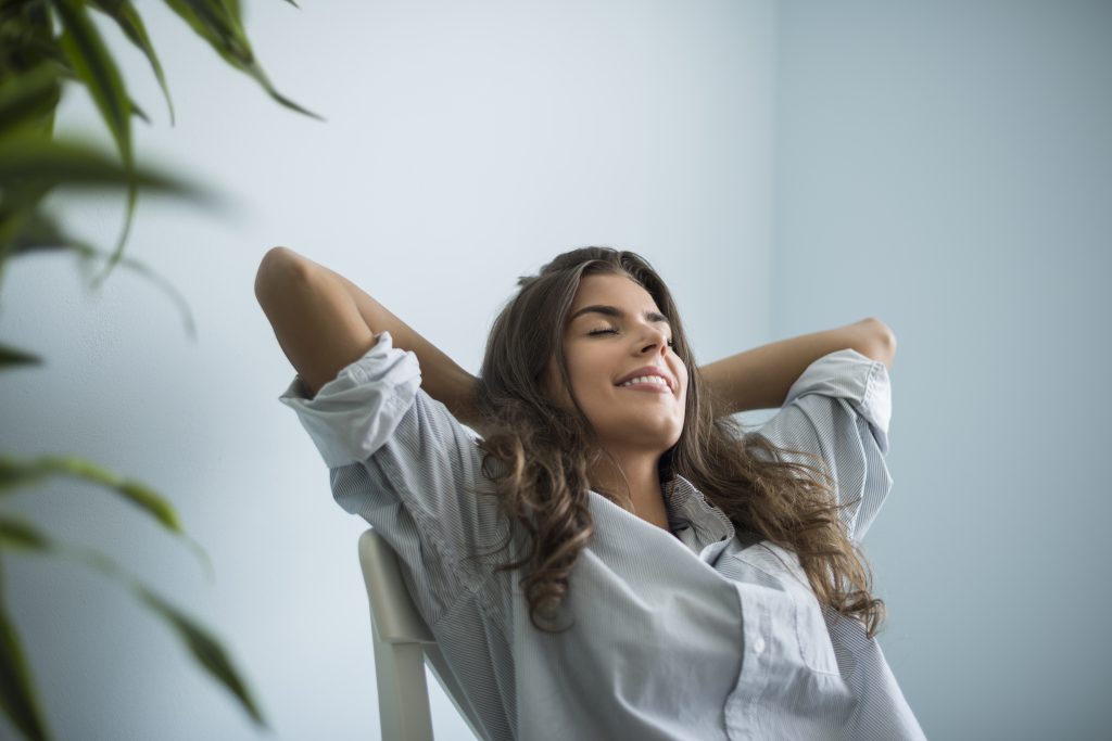 A happy, smiling woman relaxing outdoors.