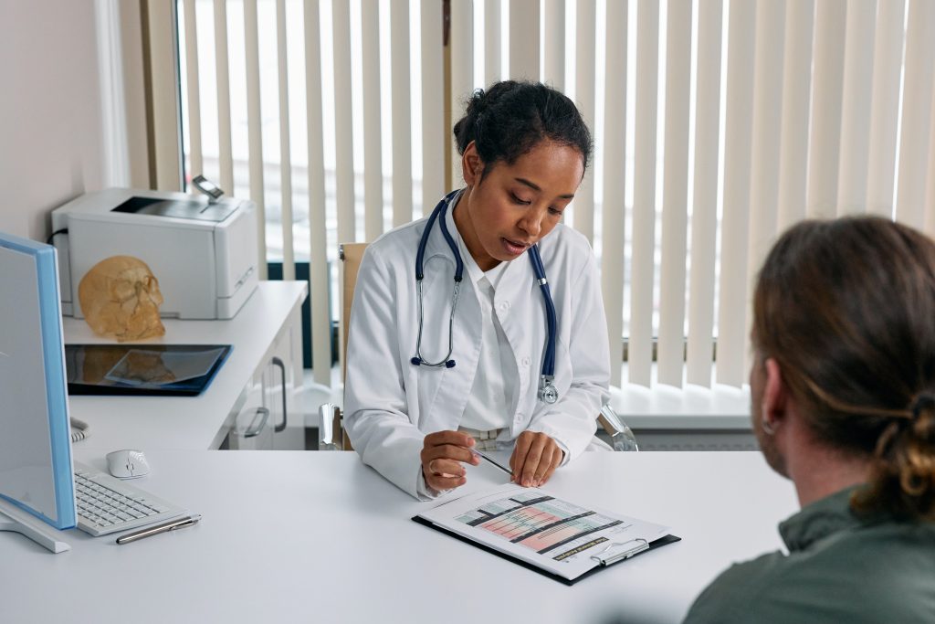 A woman doctor examining a person’s health report, highlighting the importance of addressing causes for better sleep.