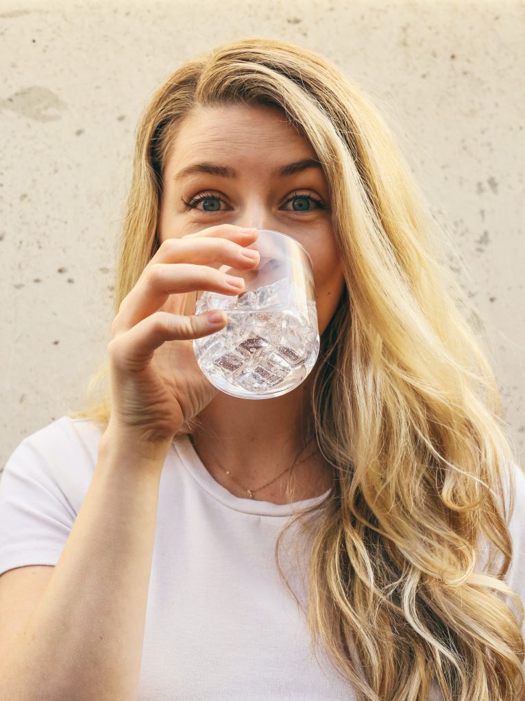 A woman drinking water, symbolizing the role of proper hydration, potentially reversing prediabetes.