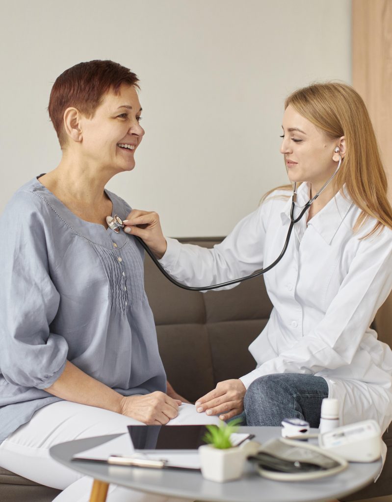 A female doctor examining a patient, emphasizing the importance of scheduling routine checkups.