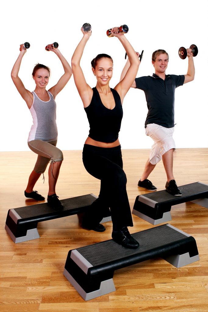 A group of fitness enthusiasts performing training with dumbbells.