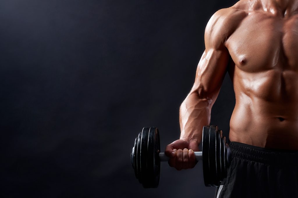 A man lifting weights in a gym, demonstrating strength and concentration during his workout.
