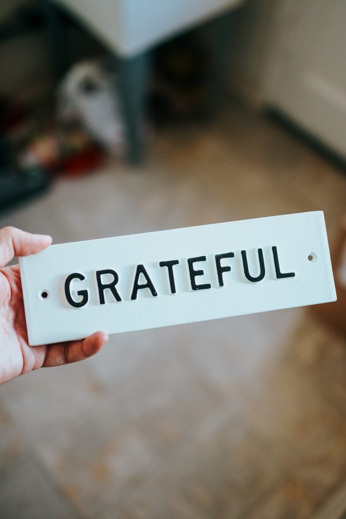 The word 'GRATEFUL' embossed on a plastic nameboard, highlighting how practicing gratitude can positively impact mental health.