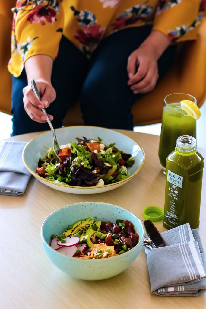 A woman enjoying a green salad, highlighting the importance of incorporating low-fat and low-calorie foods into a healthy diet.