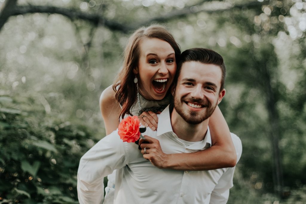 A couple in love, delightfully hugging and posing for a photo.