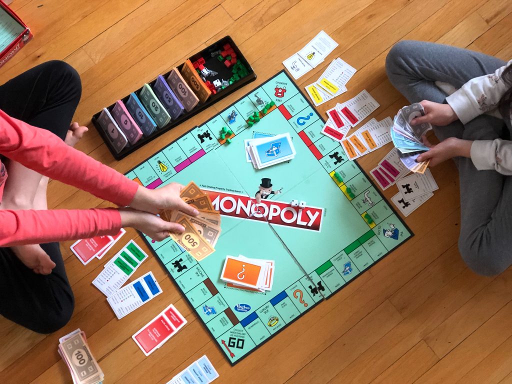Two kids playing a game of Monopoly