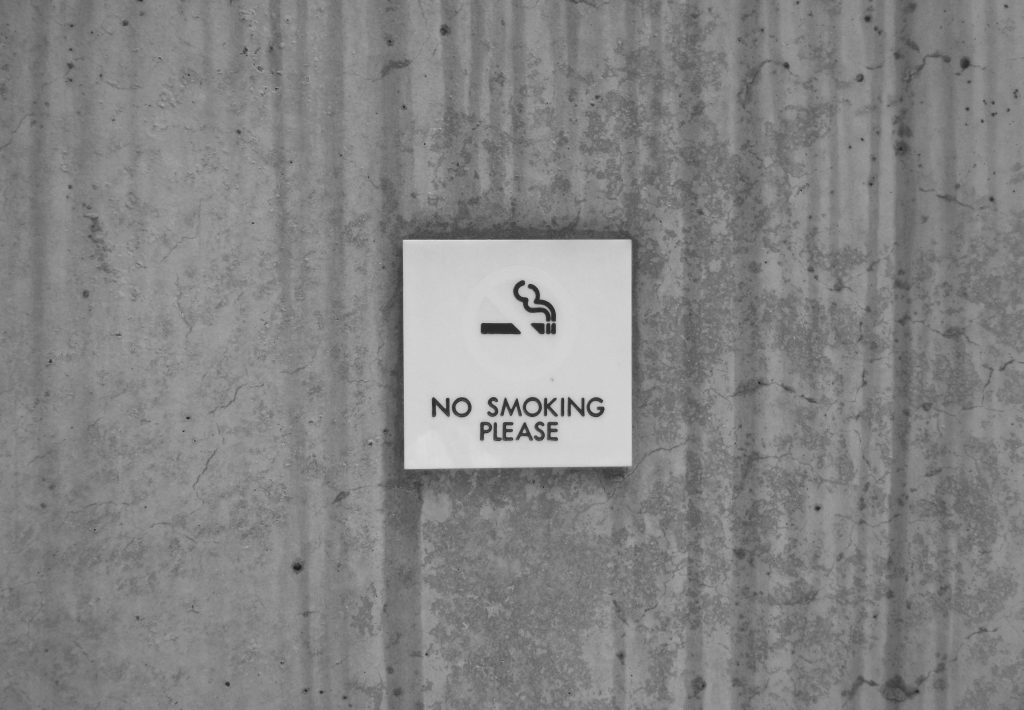 A "NO SMOKING PLEASE" signboard on a wall.