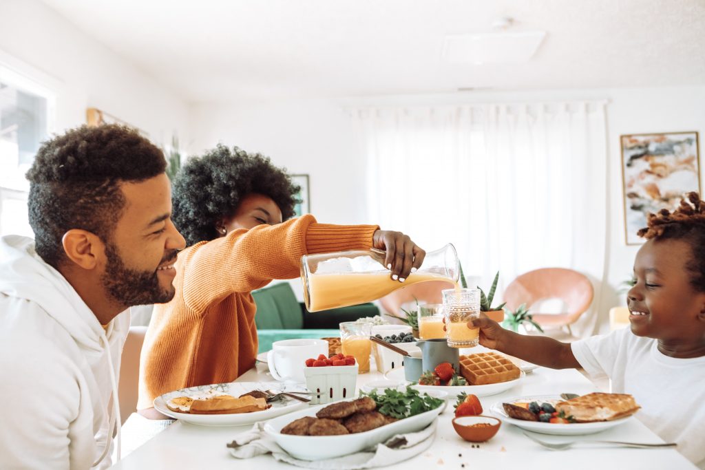 A family enjoying a meal at the dining table, highlighting the importance of creating phone-free zones during mealtimes.
