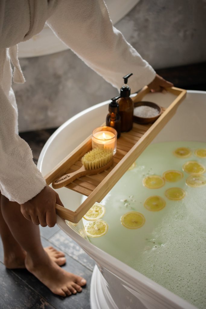 A relaxing bath being prepared with lemon slices and a bath tray, offering a soothing experience for relaxation.