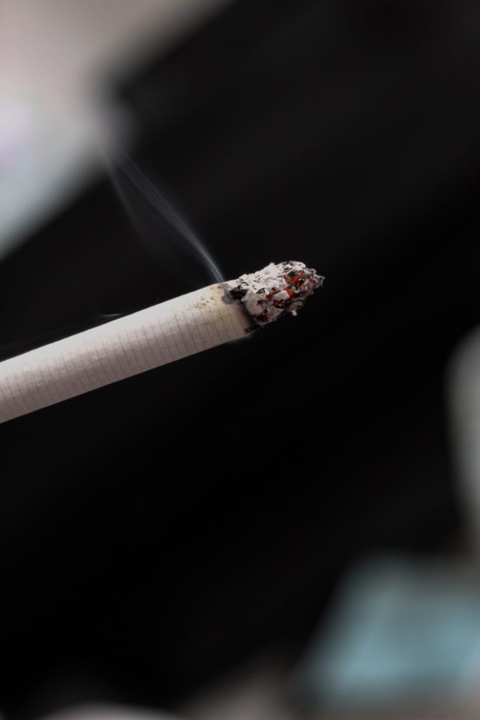 A half-burnt cigarette stick, highlighting how smoking can be a leading factor in osteoporosis.