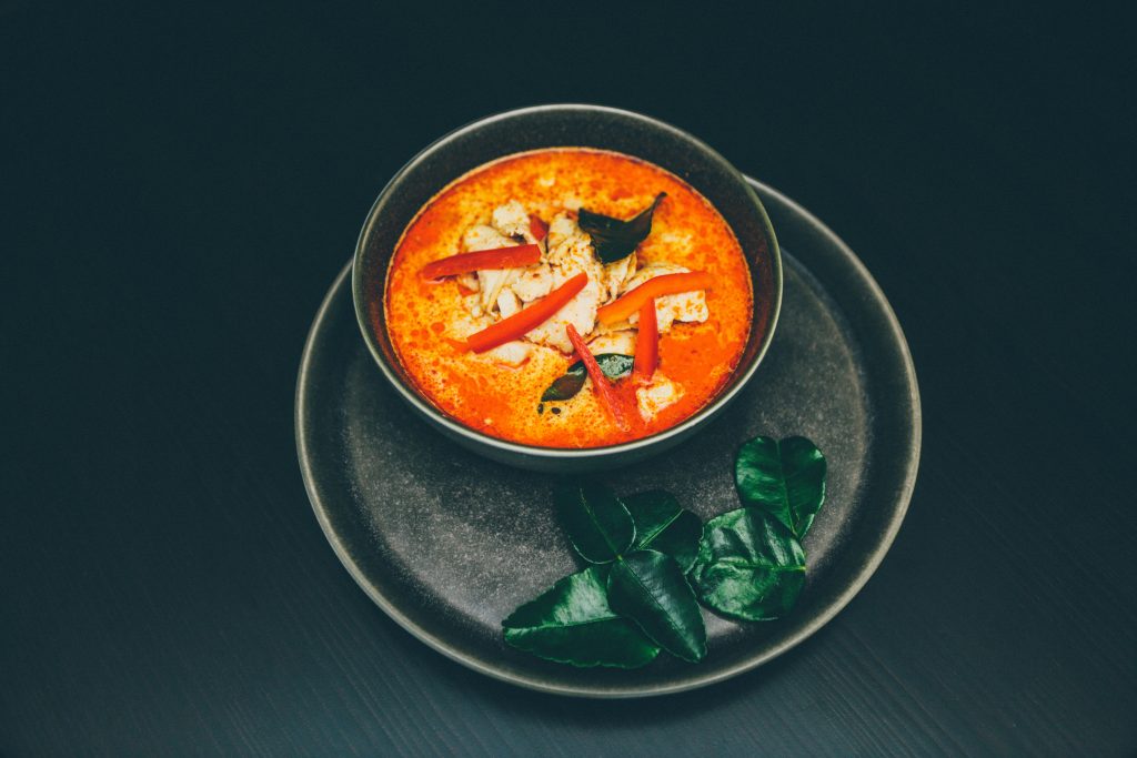 A spicy dish in a bowl, neatly presented on a black plate.