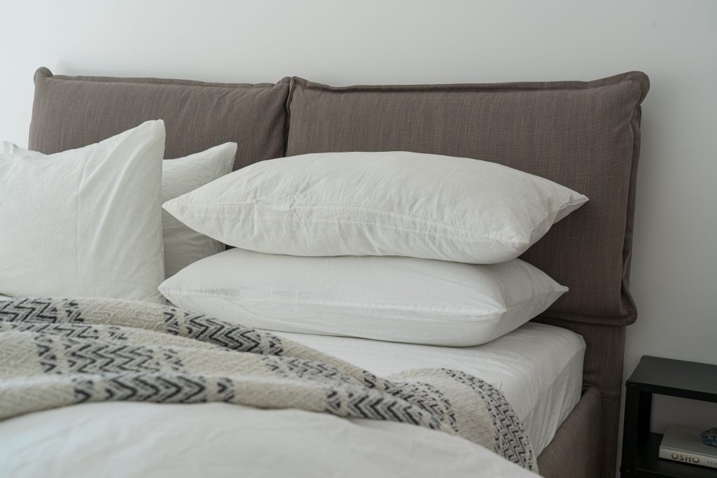 Neatly stacked clean pillows, showing how elevation can reduce throat mucus buildup.