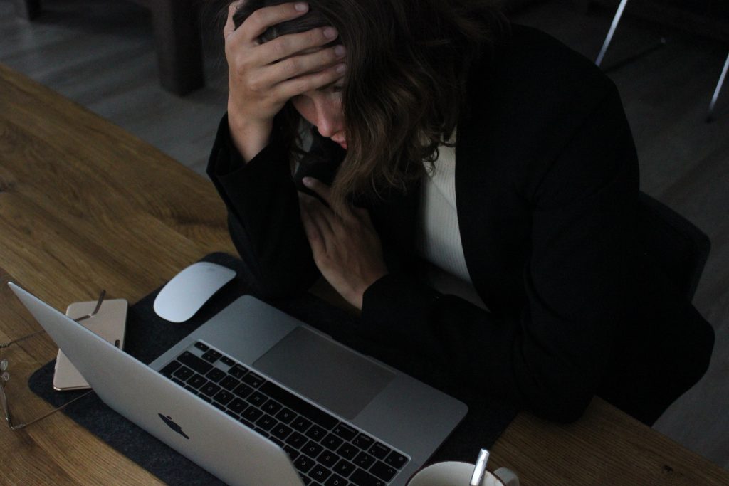 A woman working in a corporate setting, under stress.
