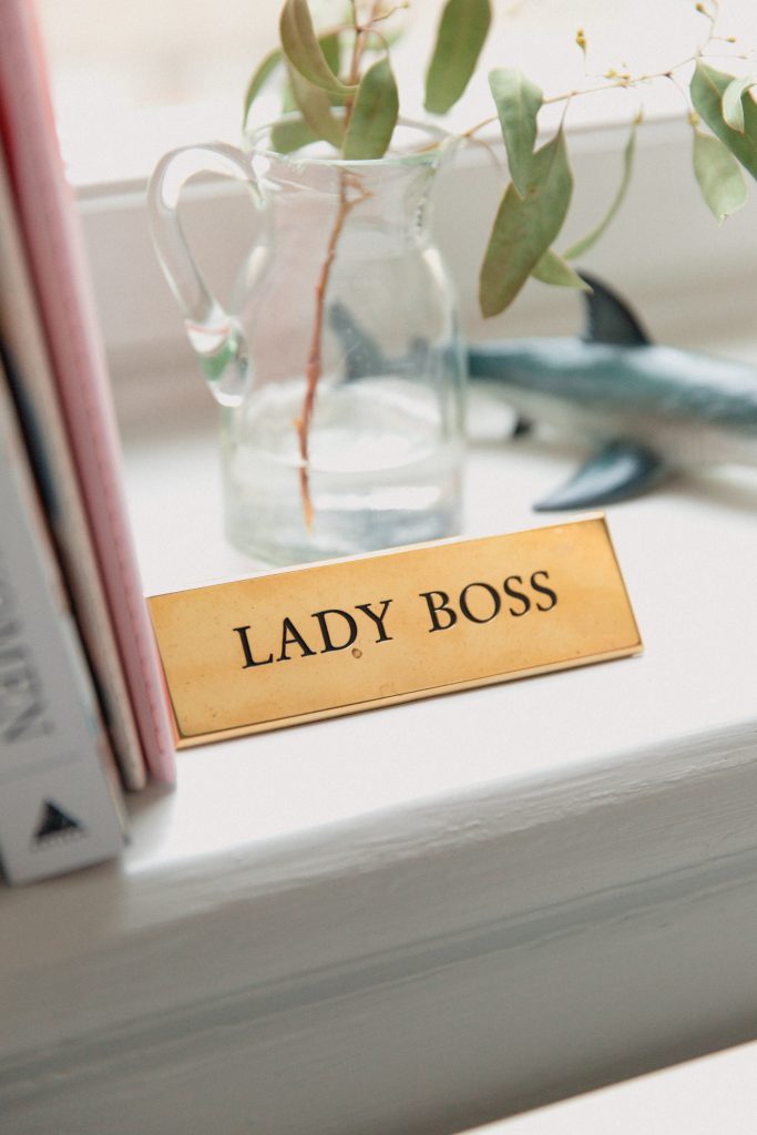 A nameplate engraved with 'Lady Boss,' placed by a window.