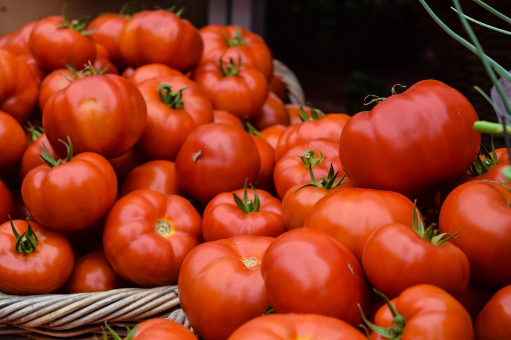 Ripe red tomatoes, high in vitamin C, potassium, and lycopene, arranged in baskets.