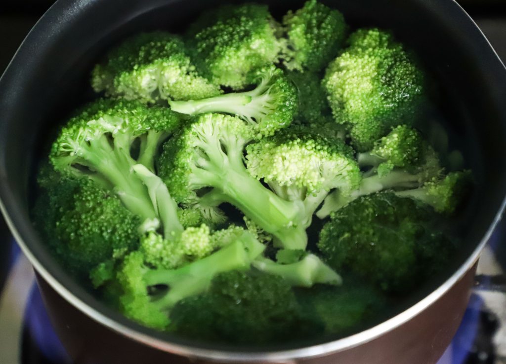 A bowl of boiled broccoli, rich in folic acid that supports brain health, immune function, and reduces fatigue.