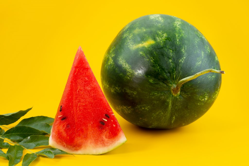 A ripe watermelon and slice with seeds, packed with water, nutrients, and low in calories, perfect for fat fighting.