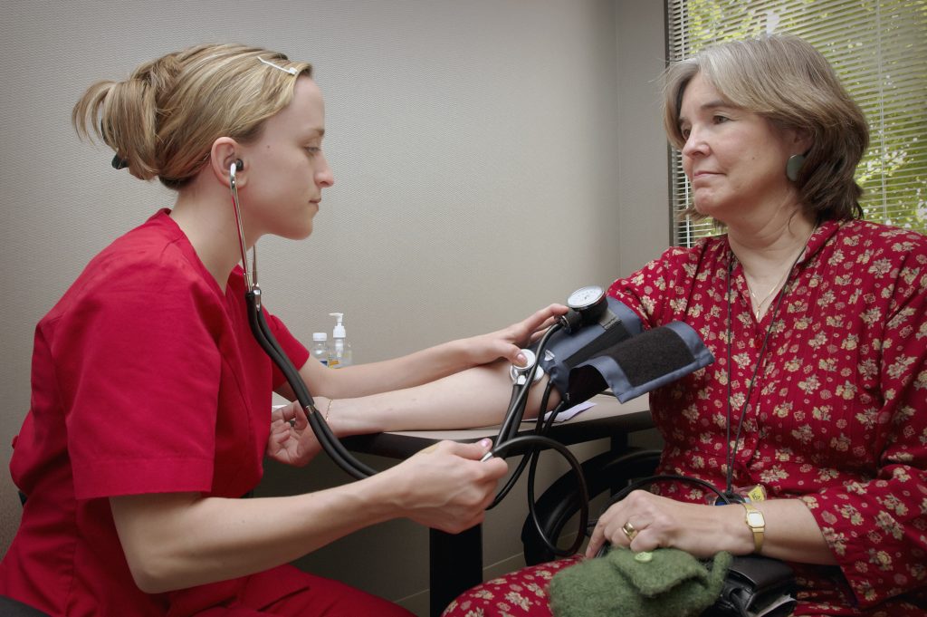 A healthcare professional checks a patient's blood pressure, emphasizing the importance of regular monitoring and knowing your numbers.