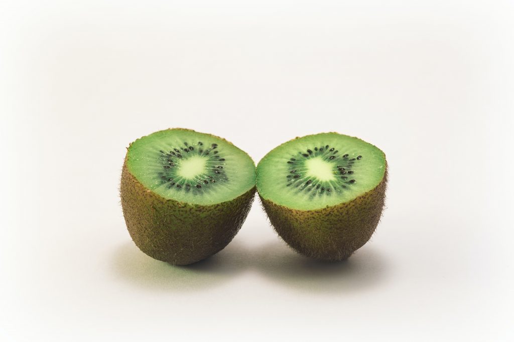 A fresh half of a ripe kiwi, promoting its ability to enhance white blood cell activity in fighting infections.