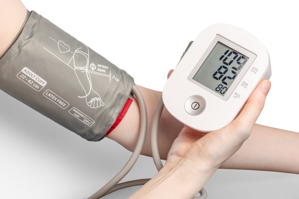 A person holds a BP monitor, emphasizing the importance of regular checks as an effective way to manage blood pressure.