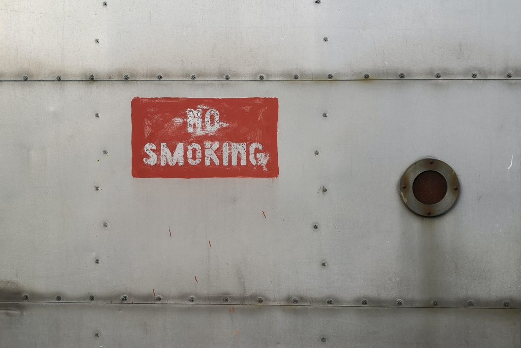 Metal surface with a red "No Smoking" sign, highlighting the risks to lung and heart health.