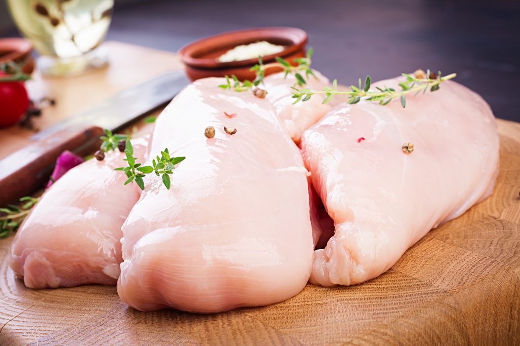 Raw chicken breasts, knife, and peppercorns, providing phosphorus that helps release energy from food during metabolism.