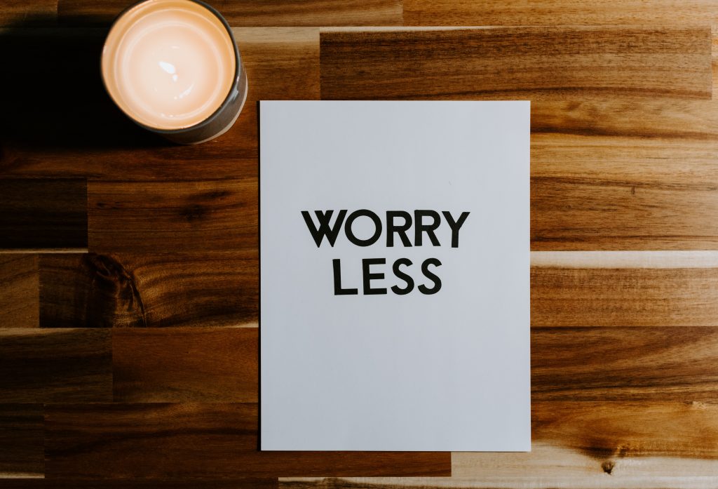 A "Worry Less" card on a wooden table next to coffee, emphasizing the importance of stress relief for immune health.