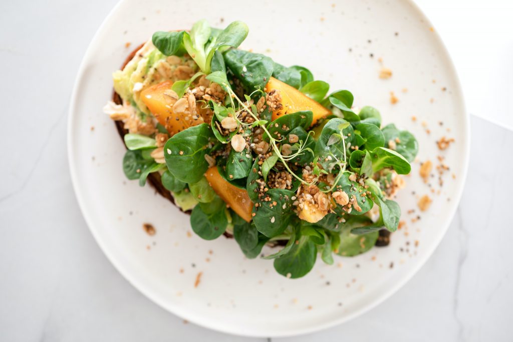 A continental dish garnished with fresh greens and whole grains .