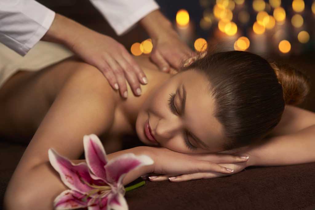 A young woman enjoying a spa body massage, helping to reduce stress and potentially alleviate menstrual cramps.