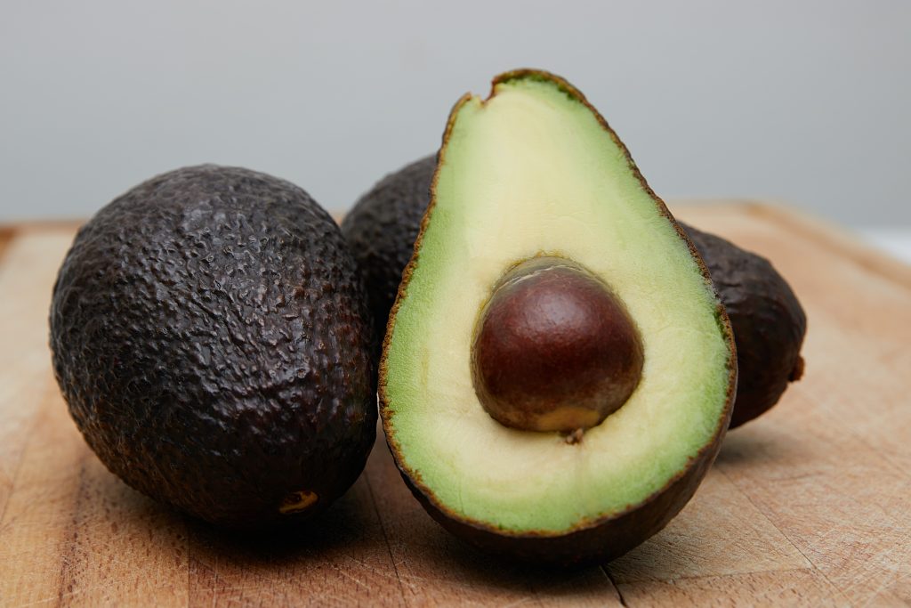 Close-up of sliced and whole avocado showcasing its potassium richness.