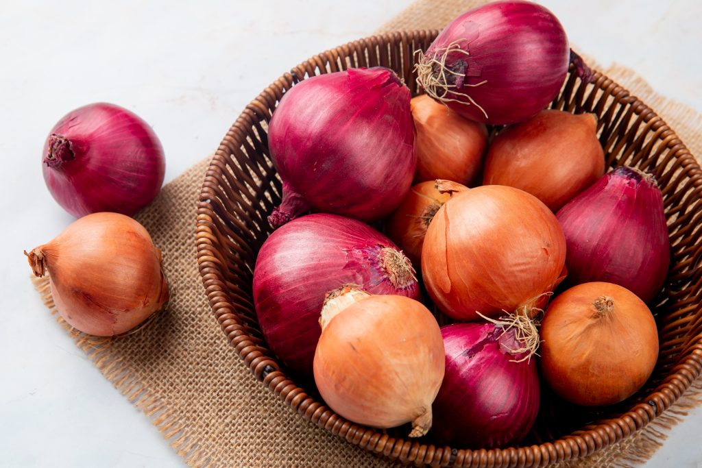 A basket filled with red and yellow onions, promoting gut health and boosting healthy bacteria for digestion.