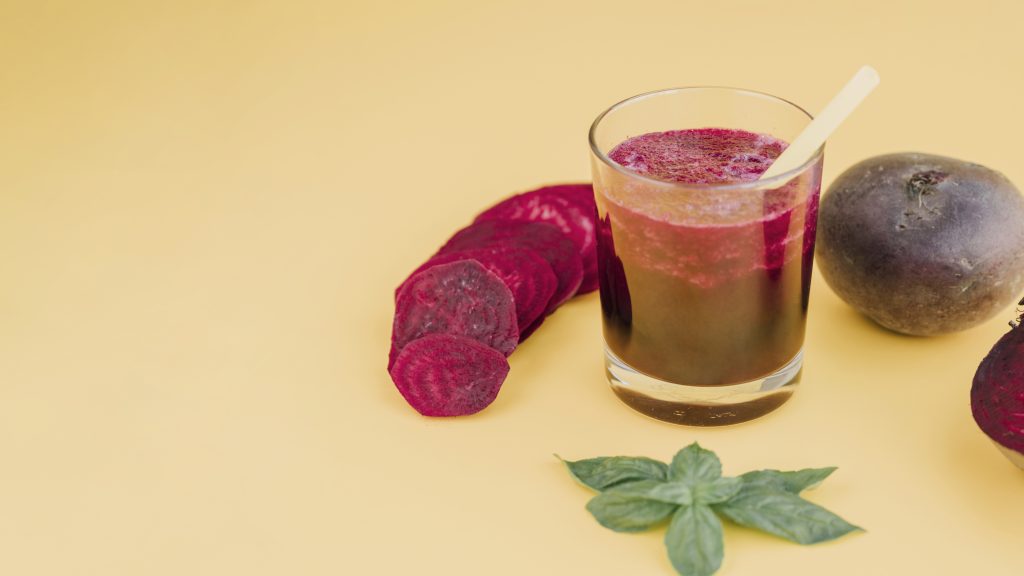 A glass of beet juice, sliced beet, and whole beet, known for improving blood flow and supporting circulation.