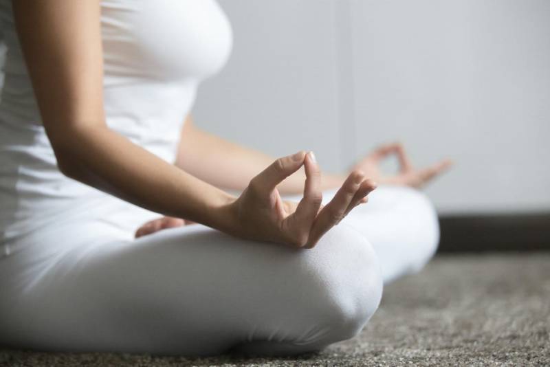 A young woman meditating and practicing yoga.