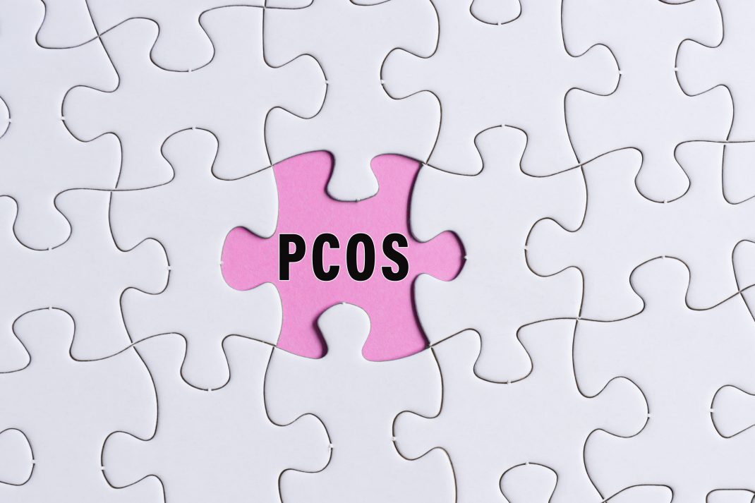 A jigsaw puzzle with a pink PCOS jigsaw tile in the center.