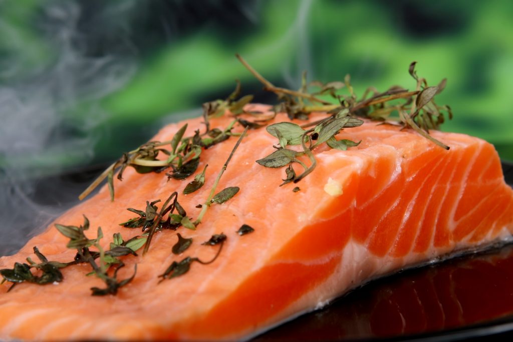 Sliced smoky seafood, rich in omega-3 fatty acids and garnished with fresh herbs, on display.