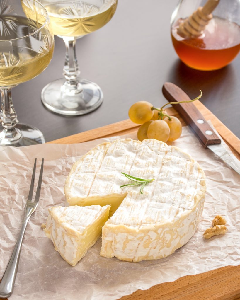 A neatly sliced piece of Parmesan cheese, an excellent source of calcium, from a large block.