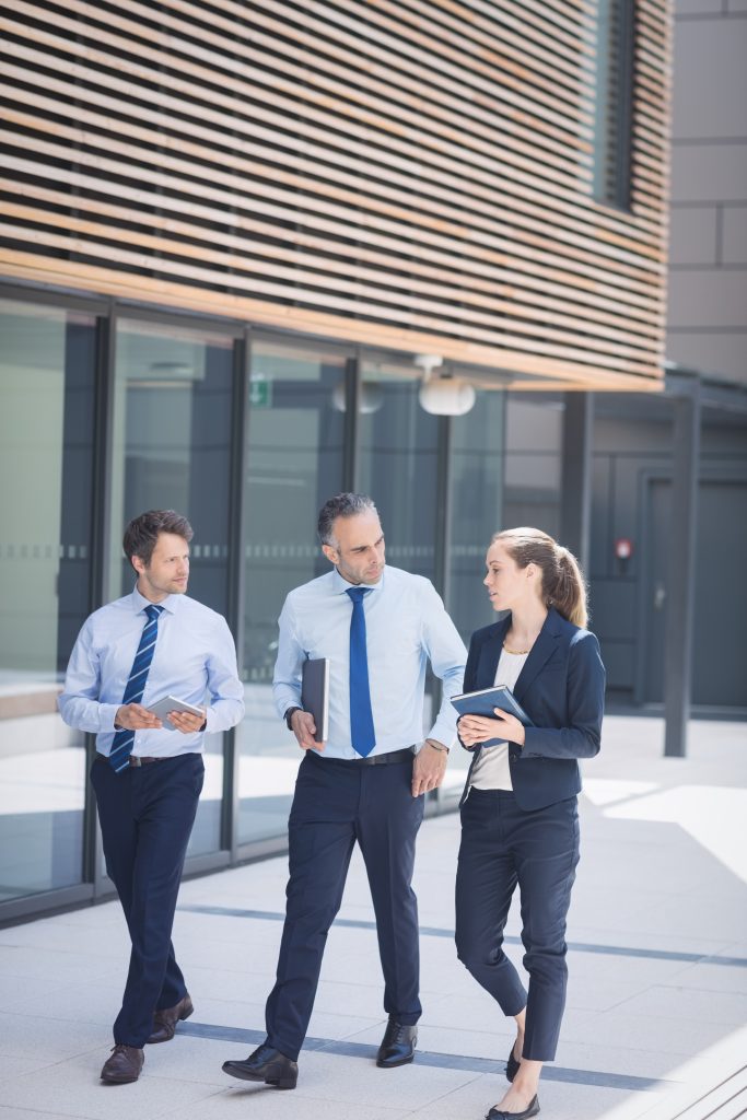 Colleagues having a serious conversation while walking by their office building.