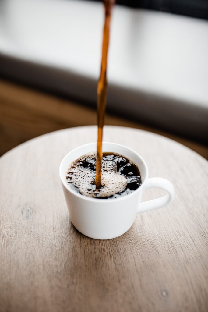 Coffee being poured into a white cup, highlighting how caffeine may cause or worsen anxiety disorders