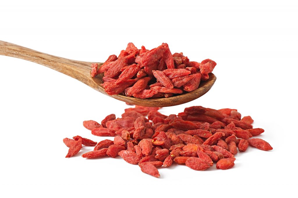 An aesthetic close-up view of a spoonful of goji berries, rich in antioxidants, against a white background.