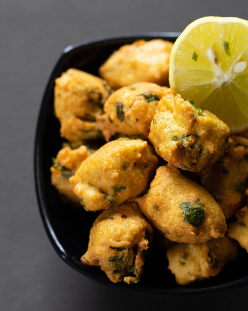 Close-up view of a bowl filled with delicious-looking fritters, highlighting how calorie-dense food can make you feel bloated.